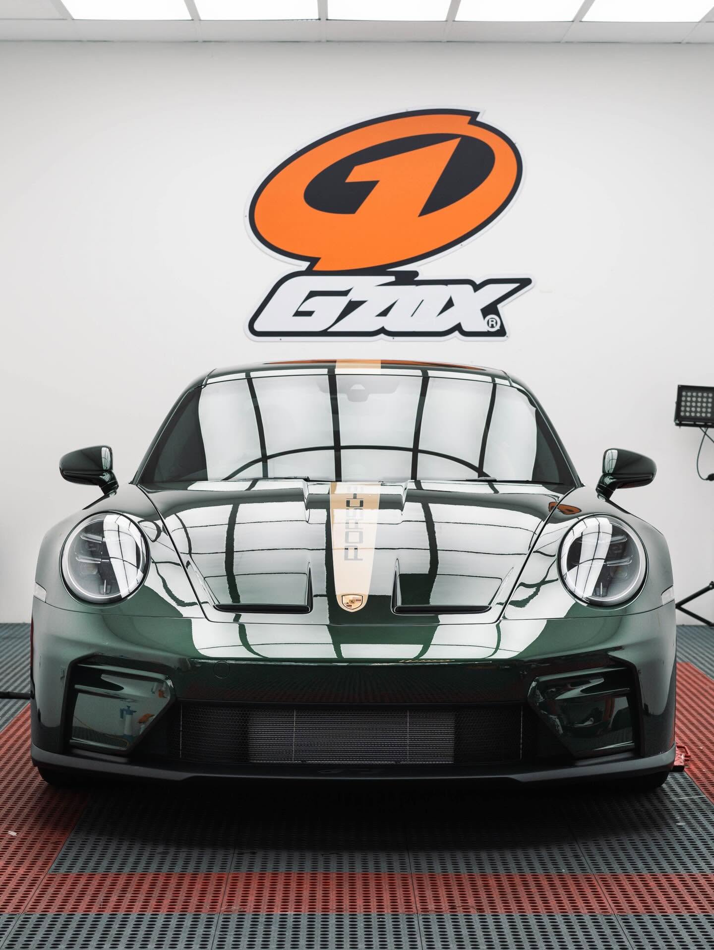 Green Porsche beneath the G’ZOX studio sign